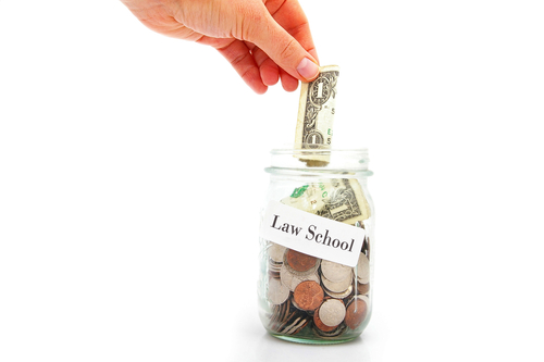 Hand,Putting,A,Dollar,Into,A,Law,School,Coin,Jar